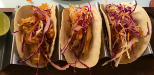 a row of tacos with cabbage and shredded cabbage