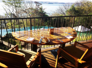 a table with a view of the water from the deck