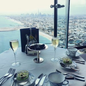 a table with plates and glasses of wine and a city view