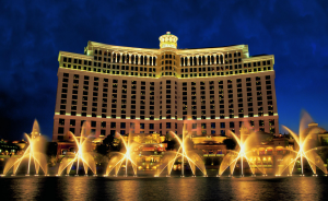 a large building with lights and water fountains with Bellagio in the background