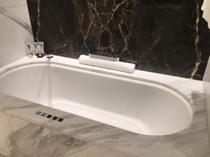 a bathtub with a roll of toilet paper on the side