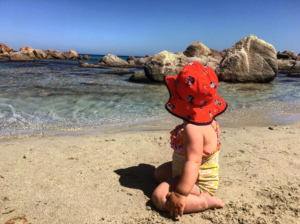 a baby sitting on a beach