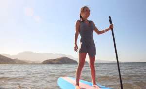 a woman standing on a surfboard in the water