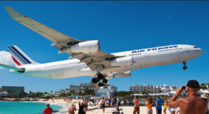 a large airplane landing on a beach