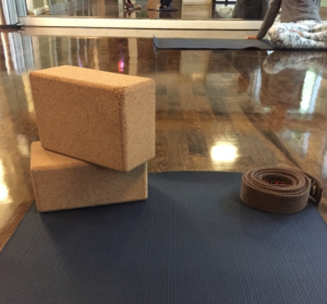 a yoga mat and two blocks on a hardwood floor