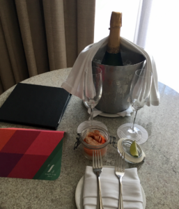 a champagne bottle in a bucket with two glasses on a table