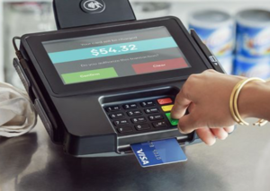 a hand pressing a credit card into a machine
