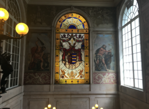 a stained glass window in a room with a painting on the wall