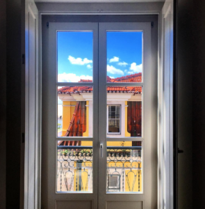 a door with a balcony and a blue sky
