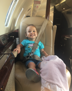 a child sitting in a seat in a plane