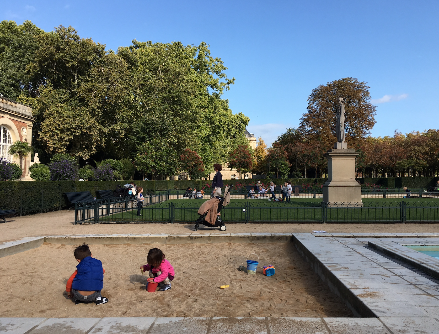 a group of kids playing in sand in a park