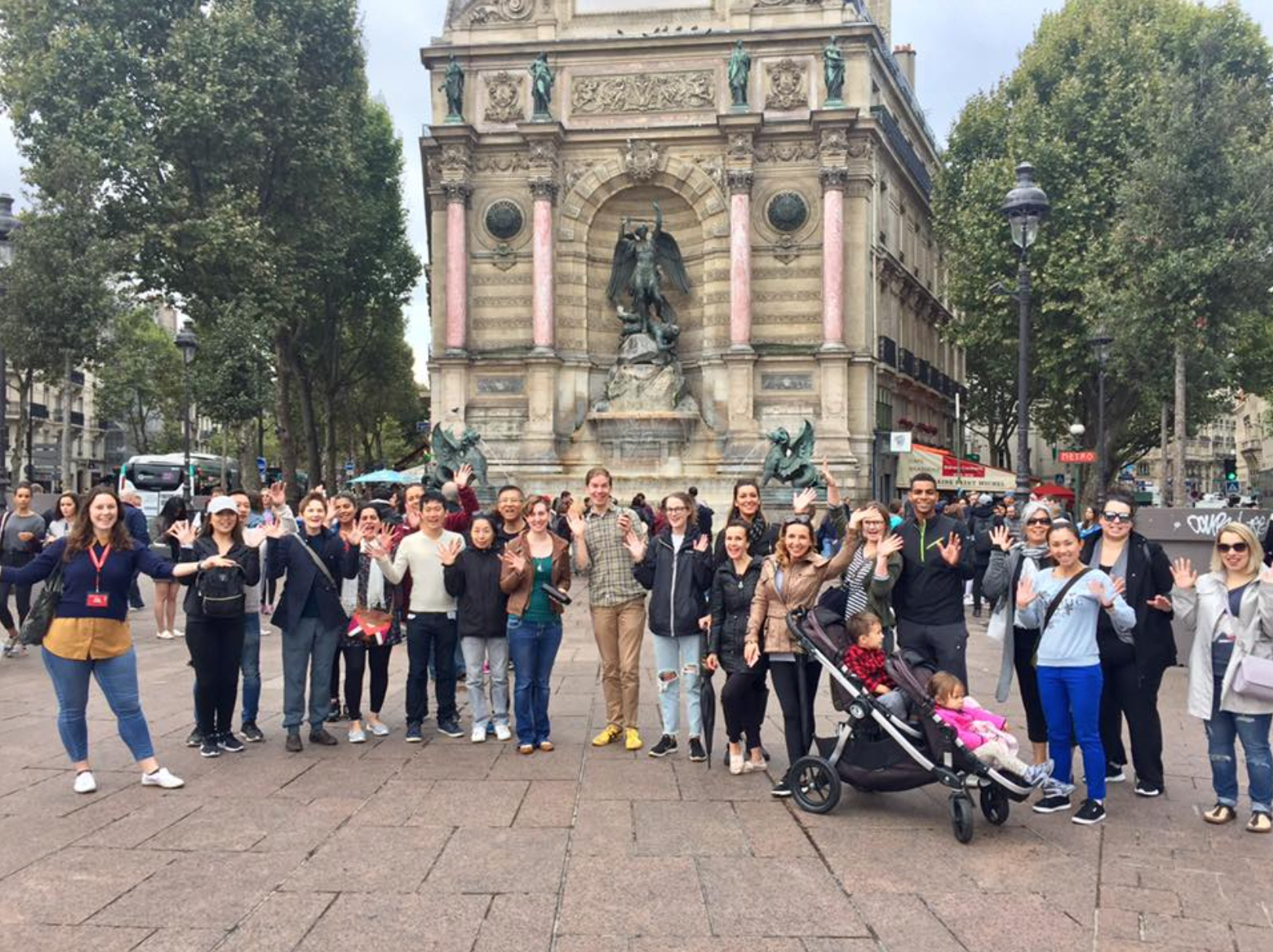 a group of people posing for a photo in front of a statue