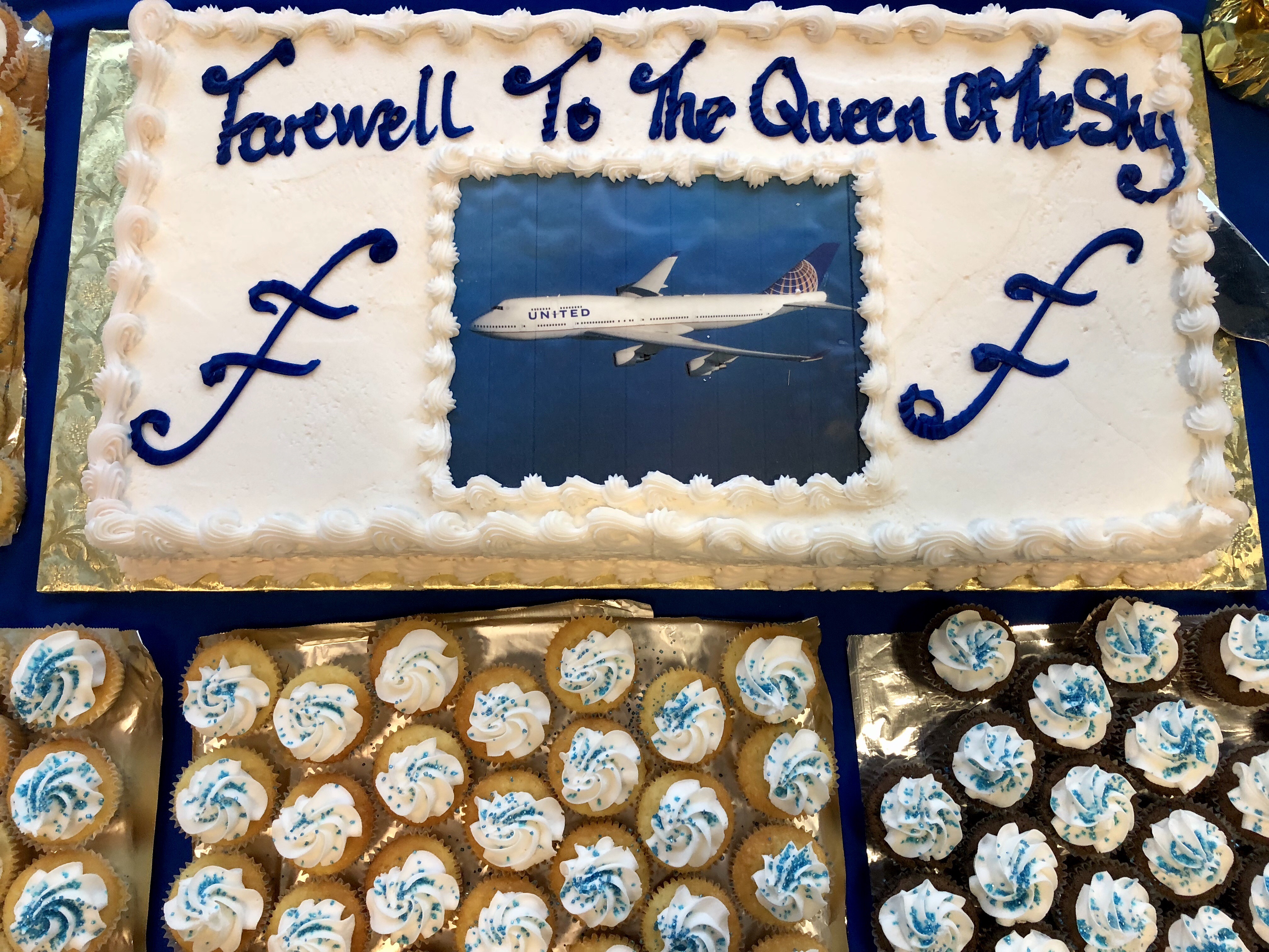 a cake with a picture of an airplane and cupcakes