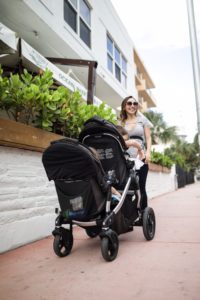 a woman pushing a stroller with a baby