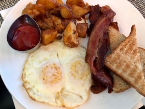 a plate of food with eggs bacon and potatoes