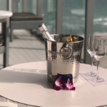 a bucket of champagne and wine glasses on a table