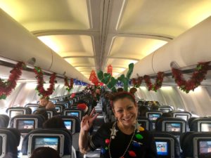 a woman sitting in an airplane with decorations on the ceiling