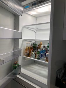a refrigerator with bottles of beer and bottles of liquid