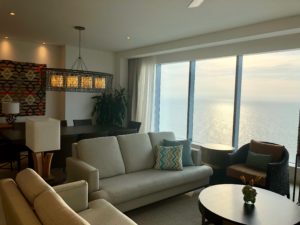 a living room with a large window overlooking the ocean