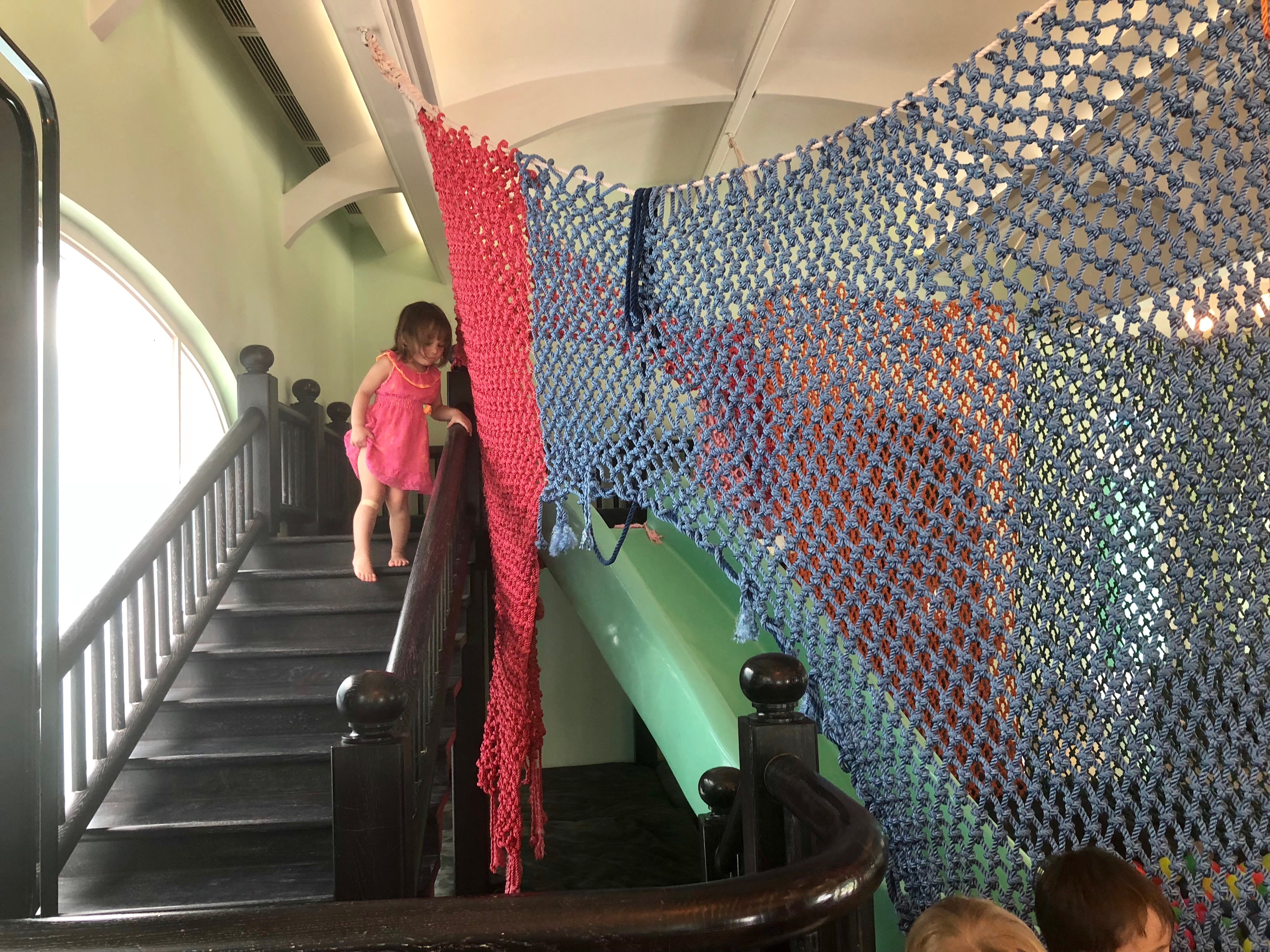 a girl climbing up a staircase with a net