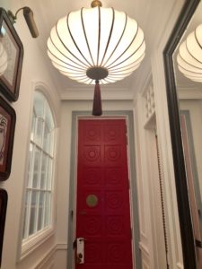 a red door with a light from the ceiling