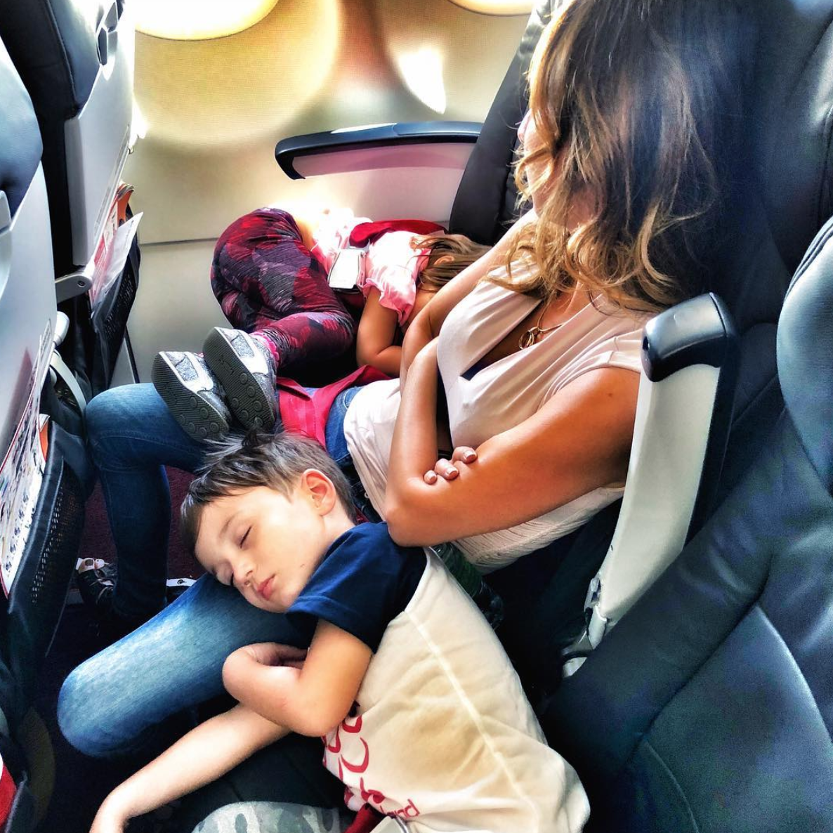 a woman sleeping with a child on a plane
