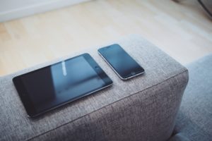 a cell phone and tablet on a couch
