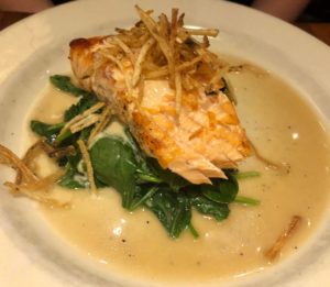 a plate of food with a piece of salmon and spinach
