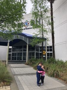 a boy hugging a girl outside of a building