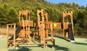 a wooden playground with trees in the background