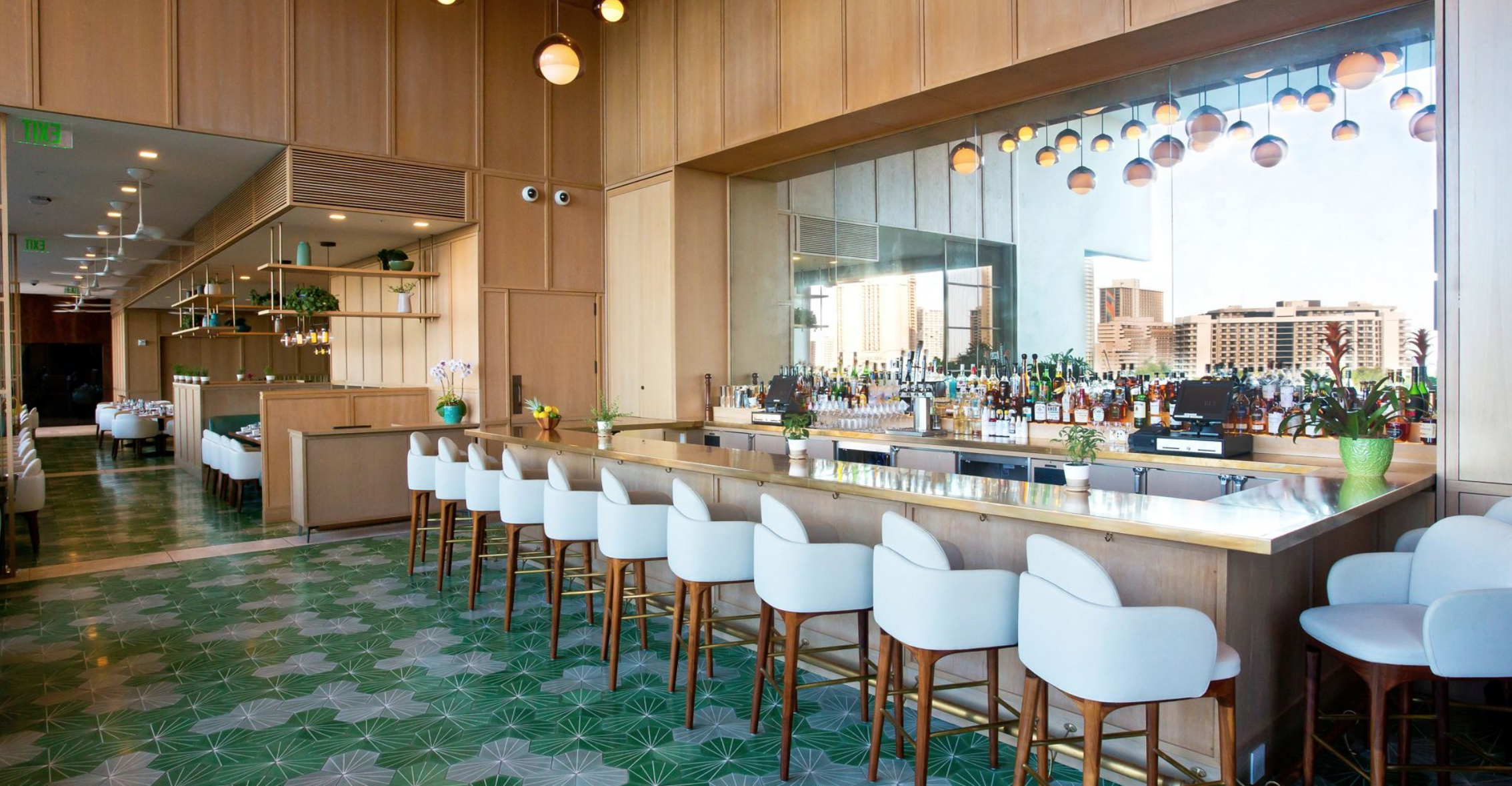 a bar with white chairs and a green floor