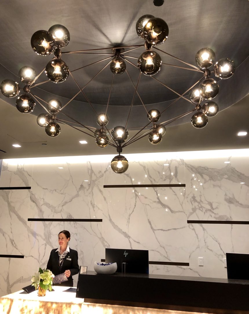 a woman standing in front of a counter with a chandelier