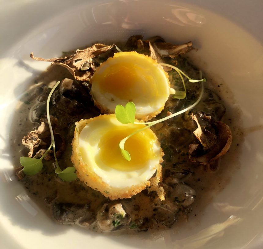 a bowl of food with eggs and mushrooms