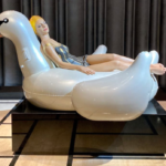 a statue of a woman lying on a floating swan